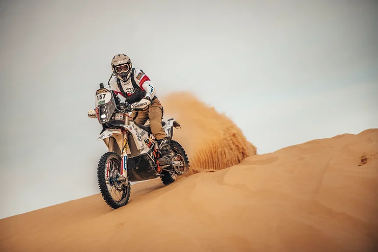 Vanessa Ruck standing beside her motorcycle, symbolizing her strength and dedication to overcoming physical challenges and participating in extreme sports.