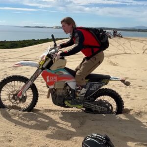 Vanessa Ruck demonstrating riding position on a motorcycle in the sand dunes of Tasmania