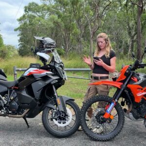 Vanessa Ruck comparing a cast front wheel and a spoked front wheel on two KTM motorcycles